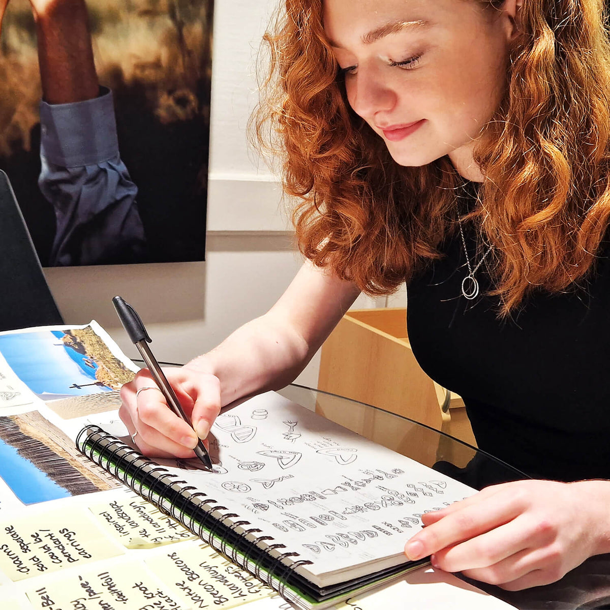 Elan sketching bespoke engagement ring concepts during the jewellery design process.