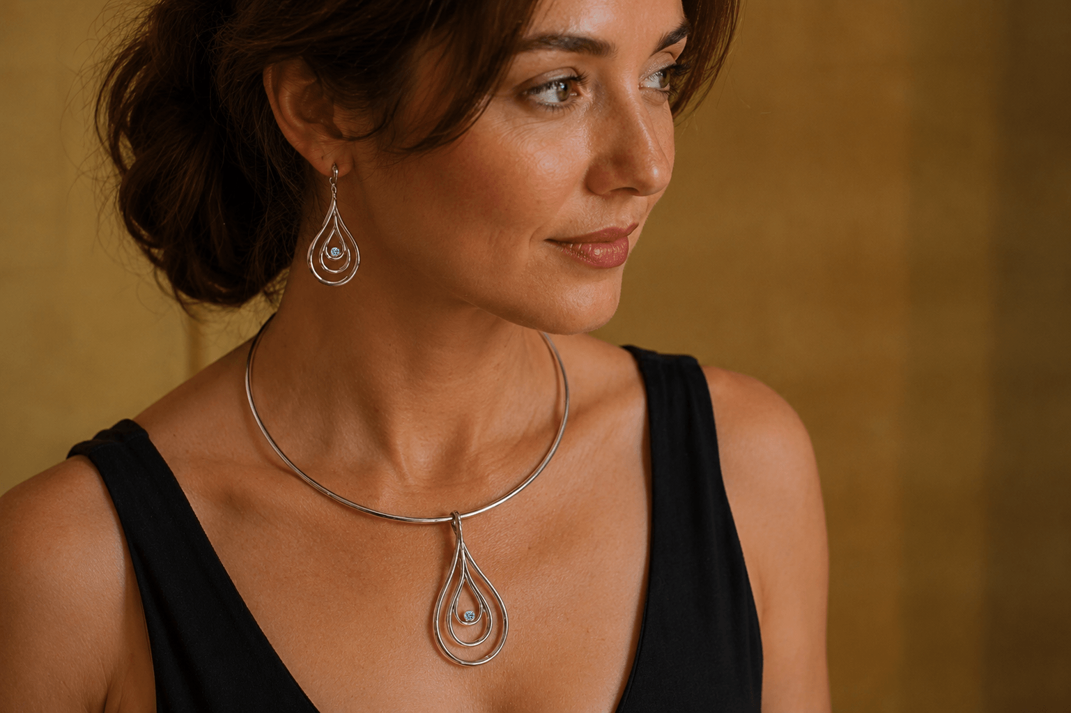 Carreg Las sterling silver torque collar with blue lab-grown diamond worn with matching earrings