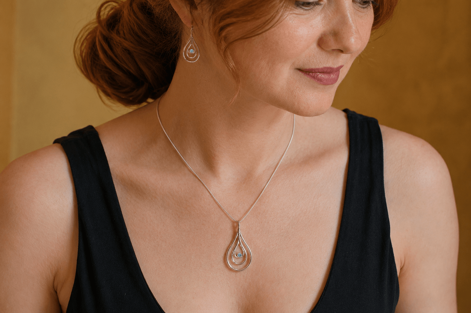 Carreg Las medium sterling silver blue diamond pendant necklace worn with matching earrings